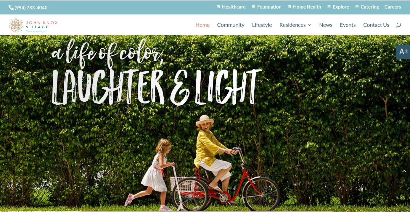 A young girl walking alongside an older woman riding a bicycle in front of a lush green hedge with the text "a life of color, laughter & light" at the top.